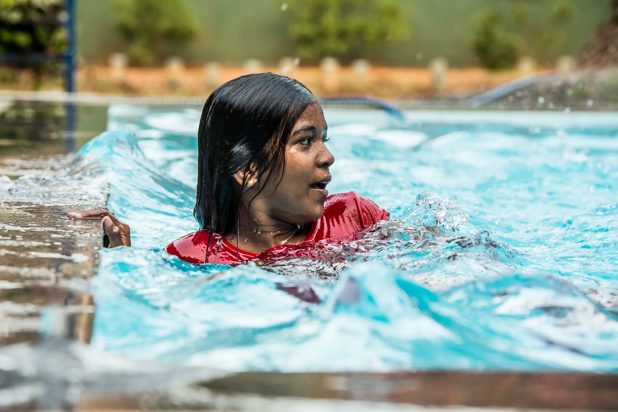 Kind h&auml;lt sich am Beckenrand fest und &uuml;bt Schwimmen im Pool des Angels Home