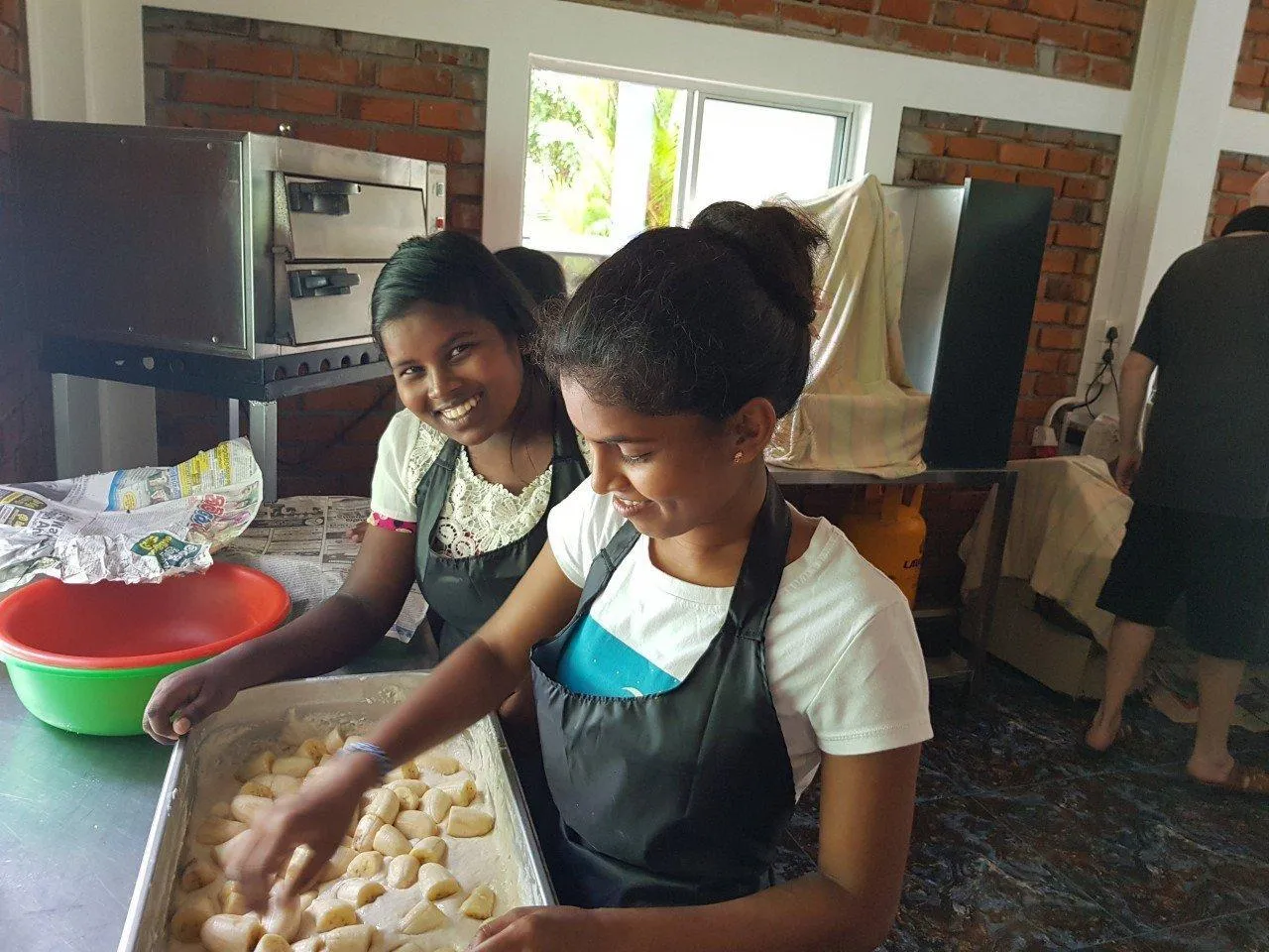 Sodi und Udenika k&auml;mpfen mit dem Teig f&uuml;r die gebackenen Bananen.