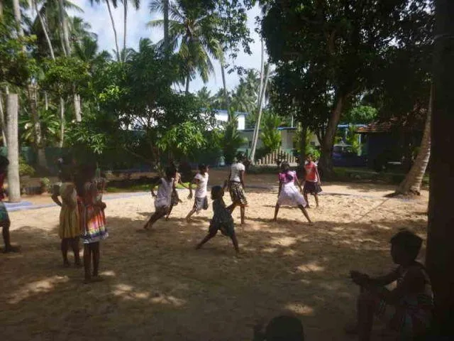 Man sieht ca. 10 M&auml;dchen, die auf einem Volleyballfeld das Spiel Kaberti spielen.