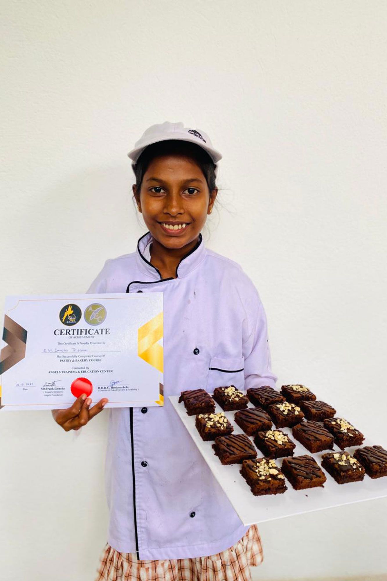 Imasha mit dem Zertifikat und ihrem Kuchen